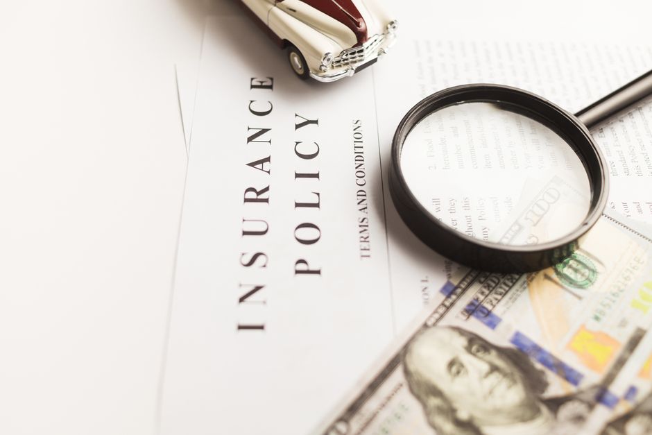 Person reviewing auto insurance documents and claim forms for glass damage