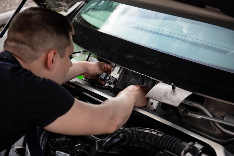 Auto glass shop technician replacing a windshield for a Texas driver